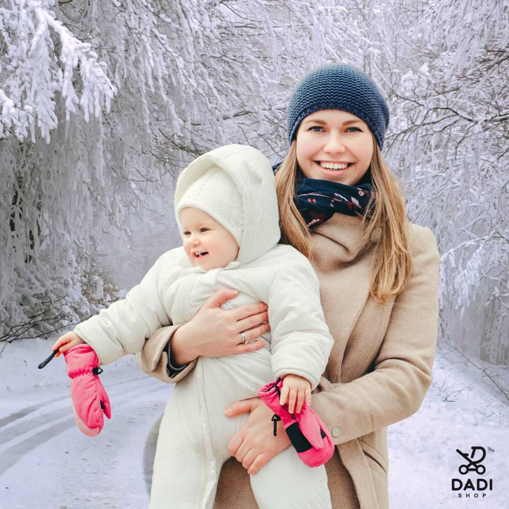 Kiedy pierwszy spacer noworodka zimą? Uśmiechnięta mama z dzieckiem w zimowej scenerii – blog Dadi-Shop